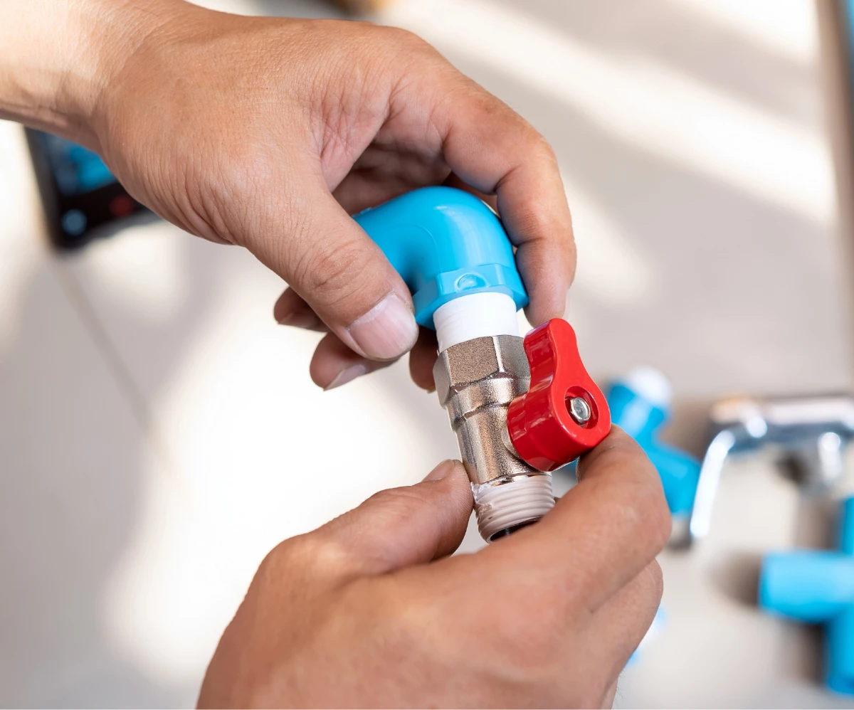 A plumber holding a part for a plumbing system.