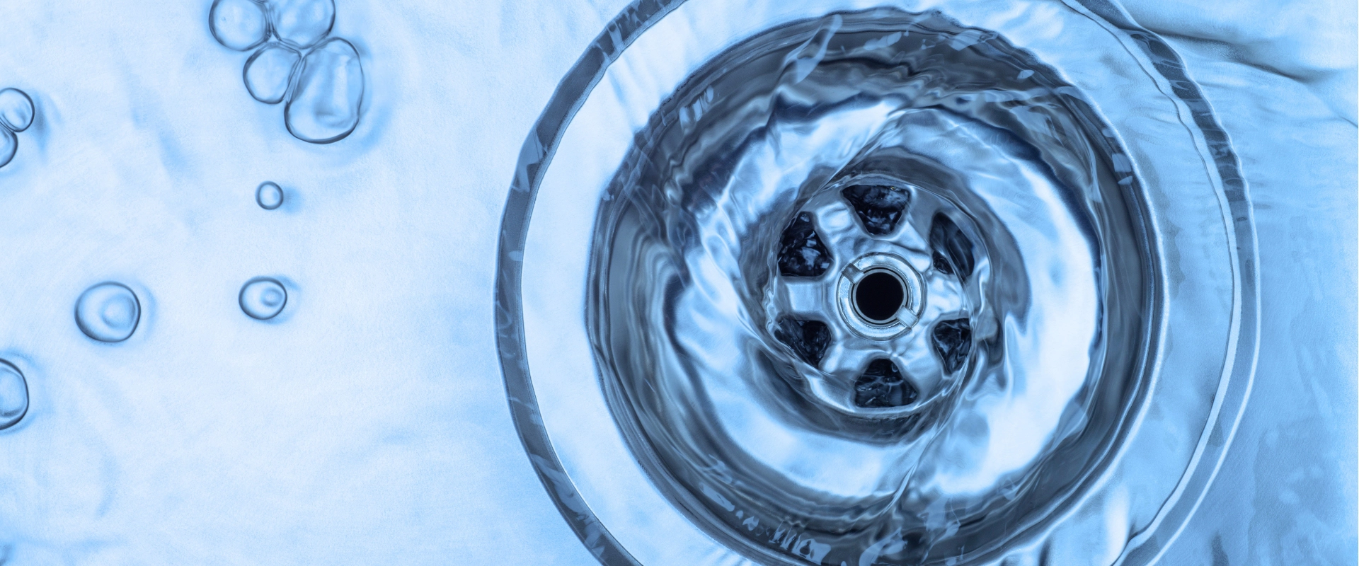 Water draining down a garbage disposal in a sink.