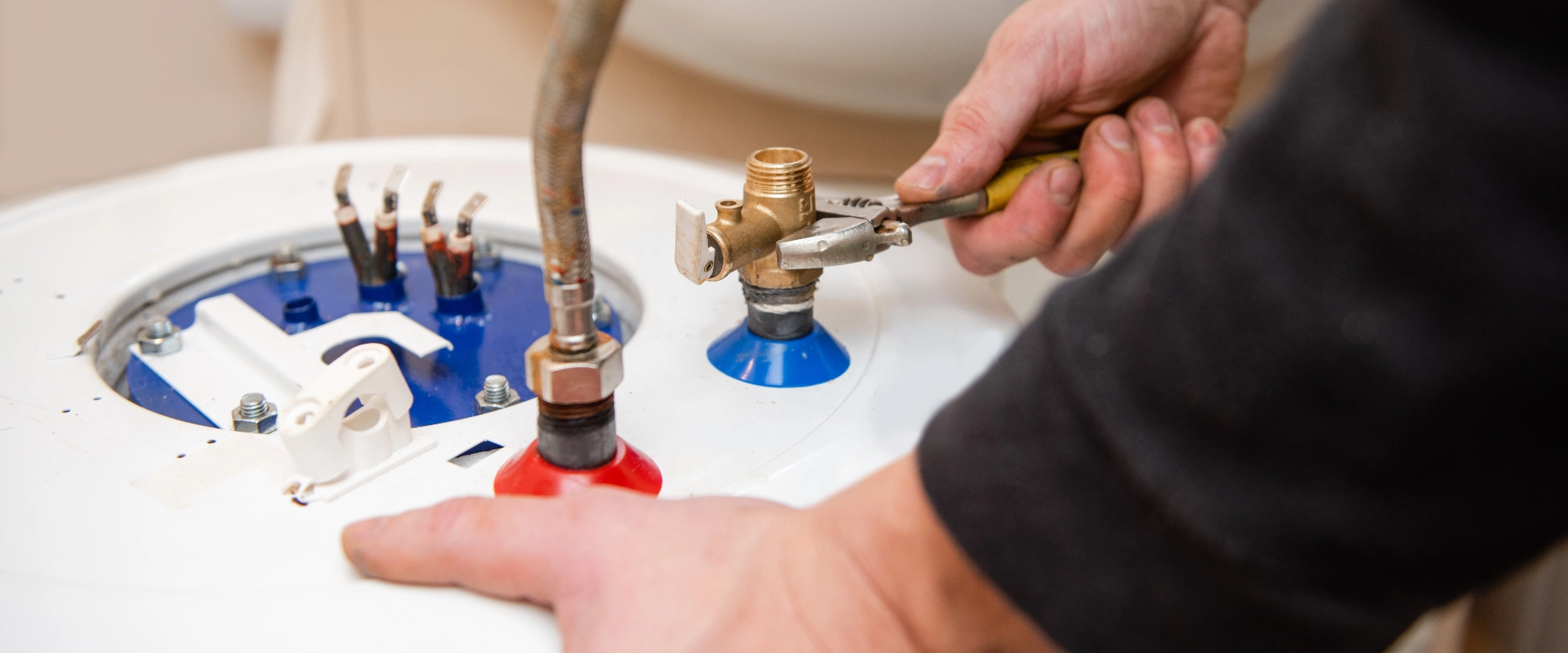 A plumber works on a water heater.