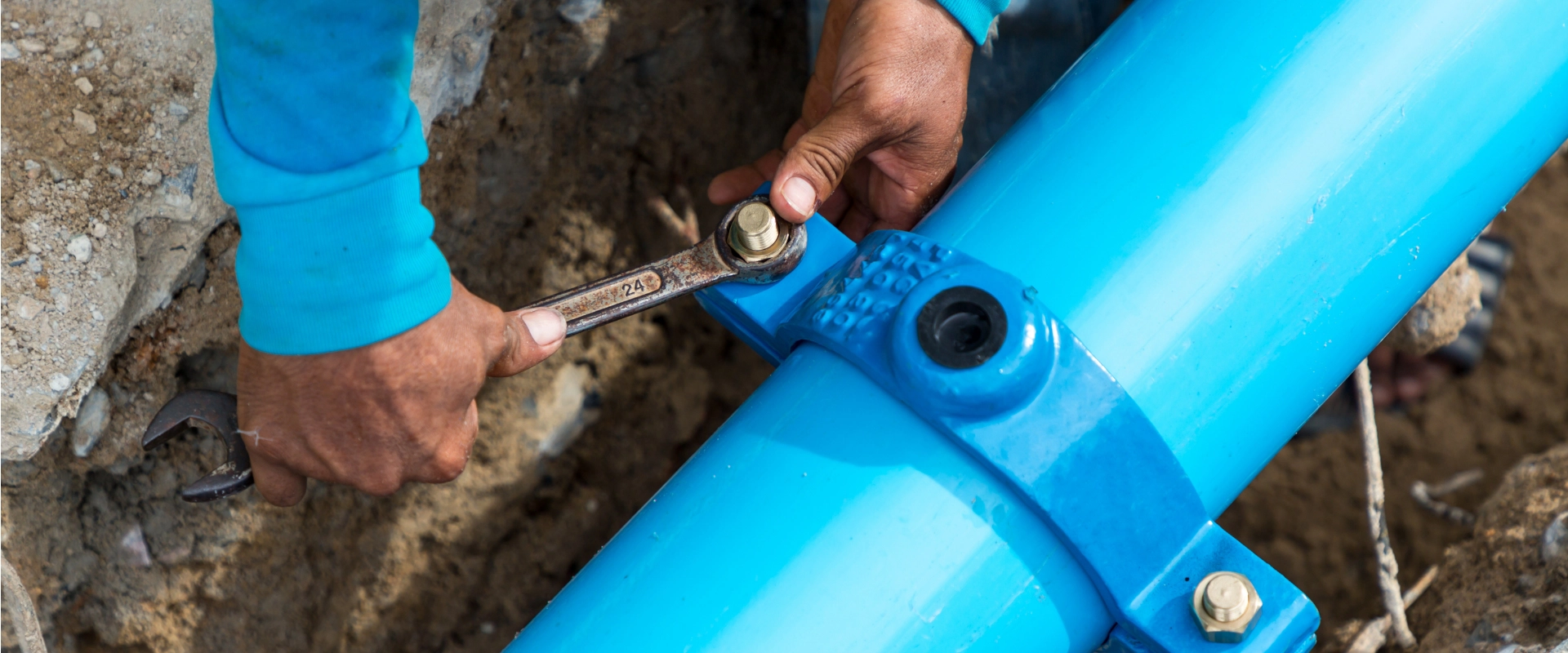 A plumber works on a water line.