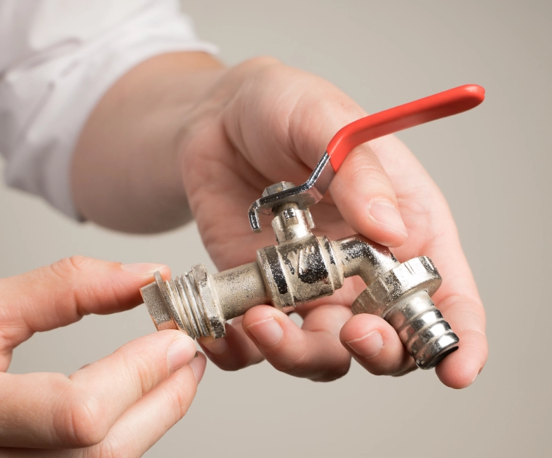 A plumber in San Antonio holds a faucet in his hands.
