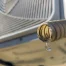 A small, dirty corrugated pipe drips water out of its end.